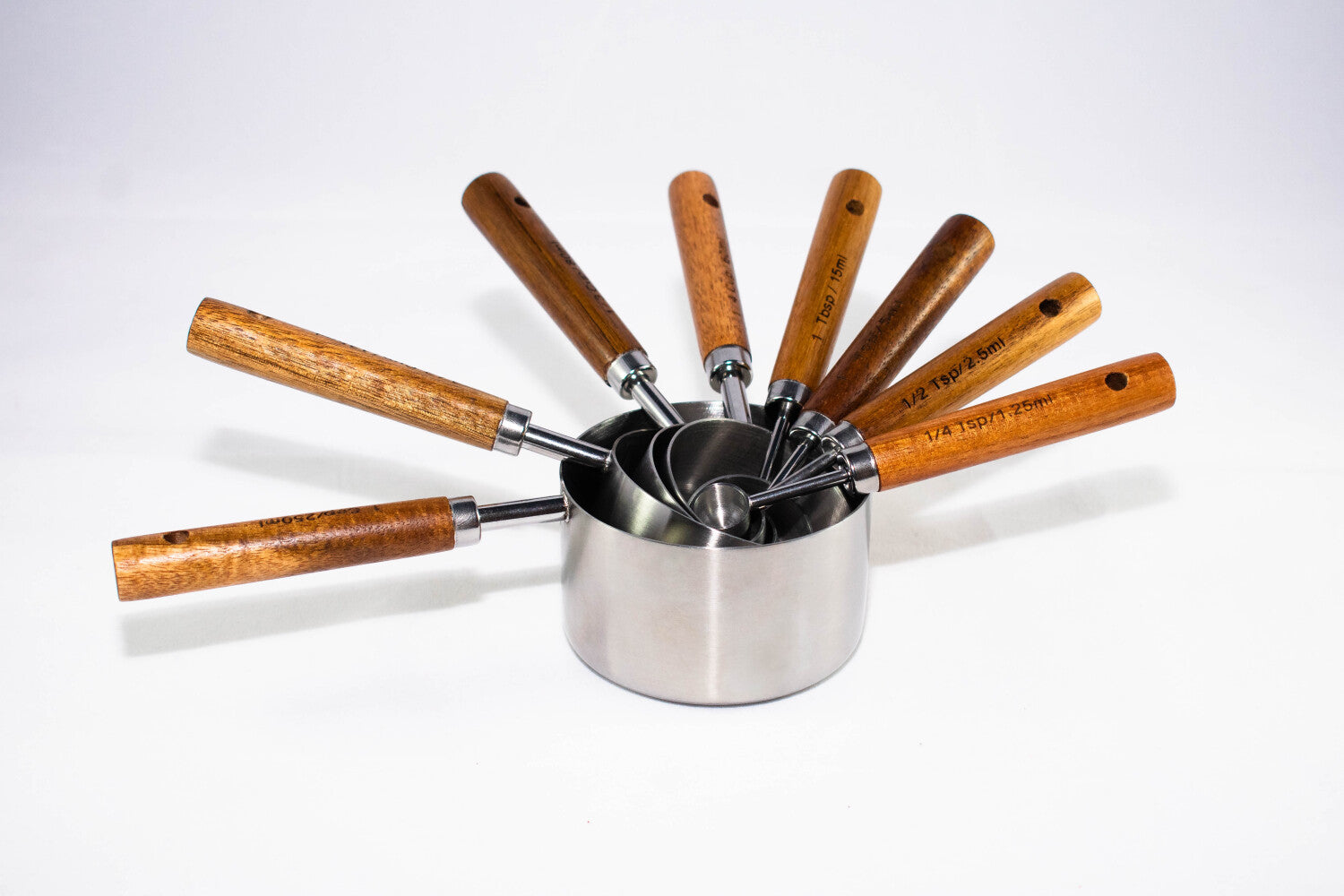 Måleskeer i rustfrit stål med træhåndtag – præcise måleskeer til madlavning og bagning i køkkenet.